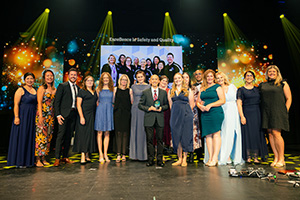 Members of the CHARM Oncology Management System Project stand onstage to accept a WA Health Excellence Award 