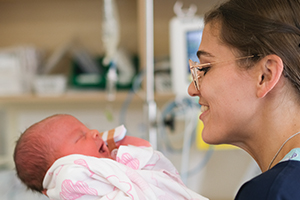A female nurses holds a newborn baby
