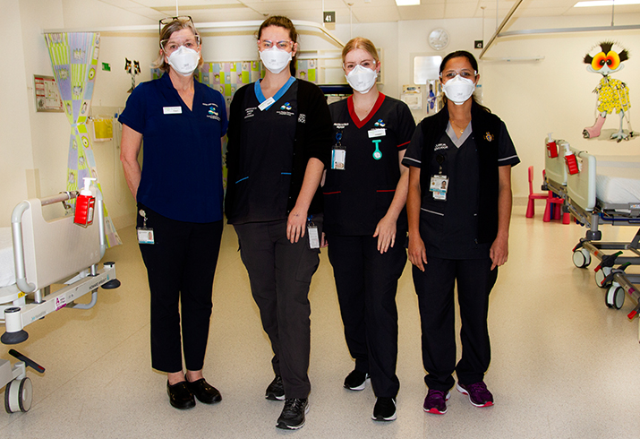 Group of nurses in children's operating theatre holding bay