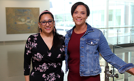 Two women standing inside a lobby