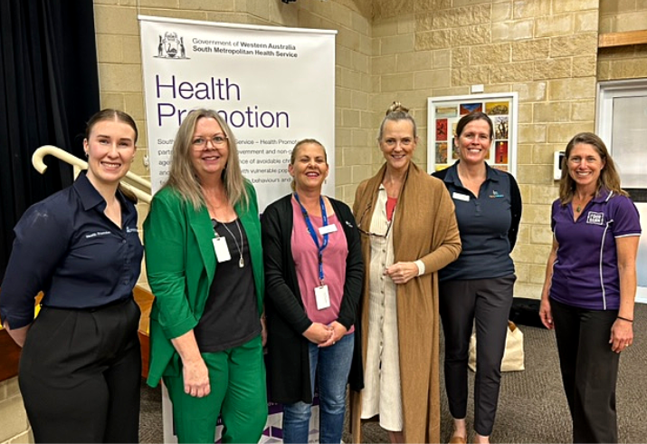 Six women involved in the workshop series aimed at preventing falls in the community, standing in line smiling.