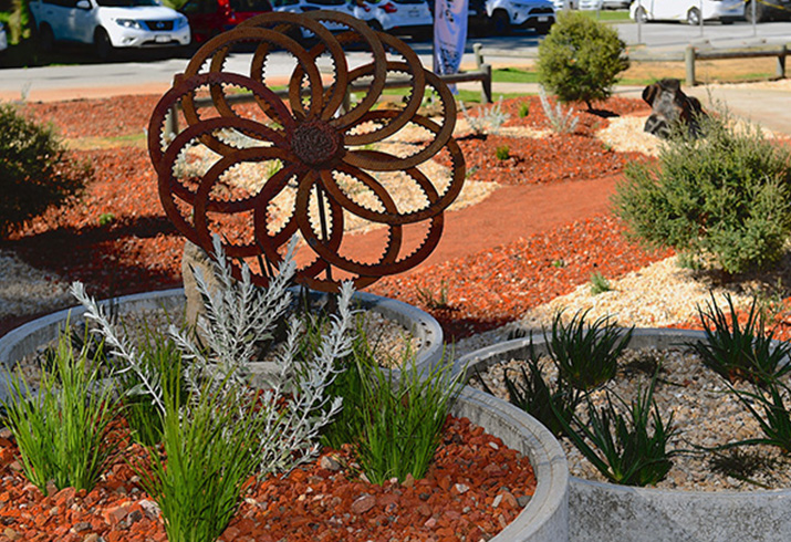 Gravel covered garden beds and paths and a garden ornament in the Rockingham General Hospital Firewise Garden