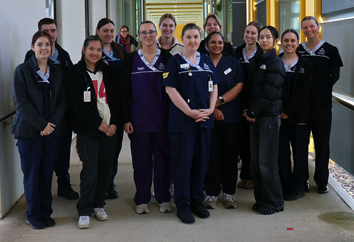 A group of about 15 graduate nurses and midwives stand together at Rockingham General Hospital